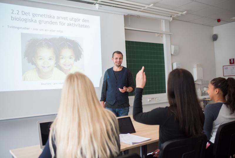 Glada studerande och lärare i klassrum